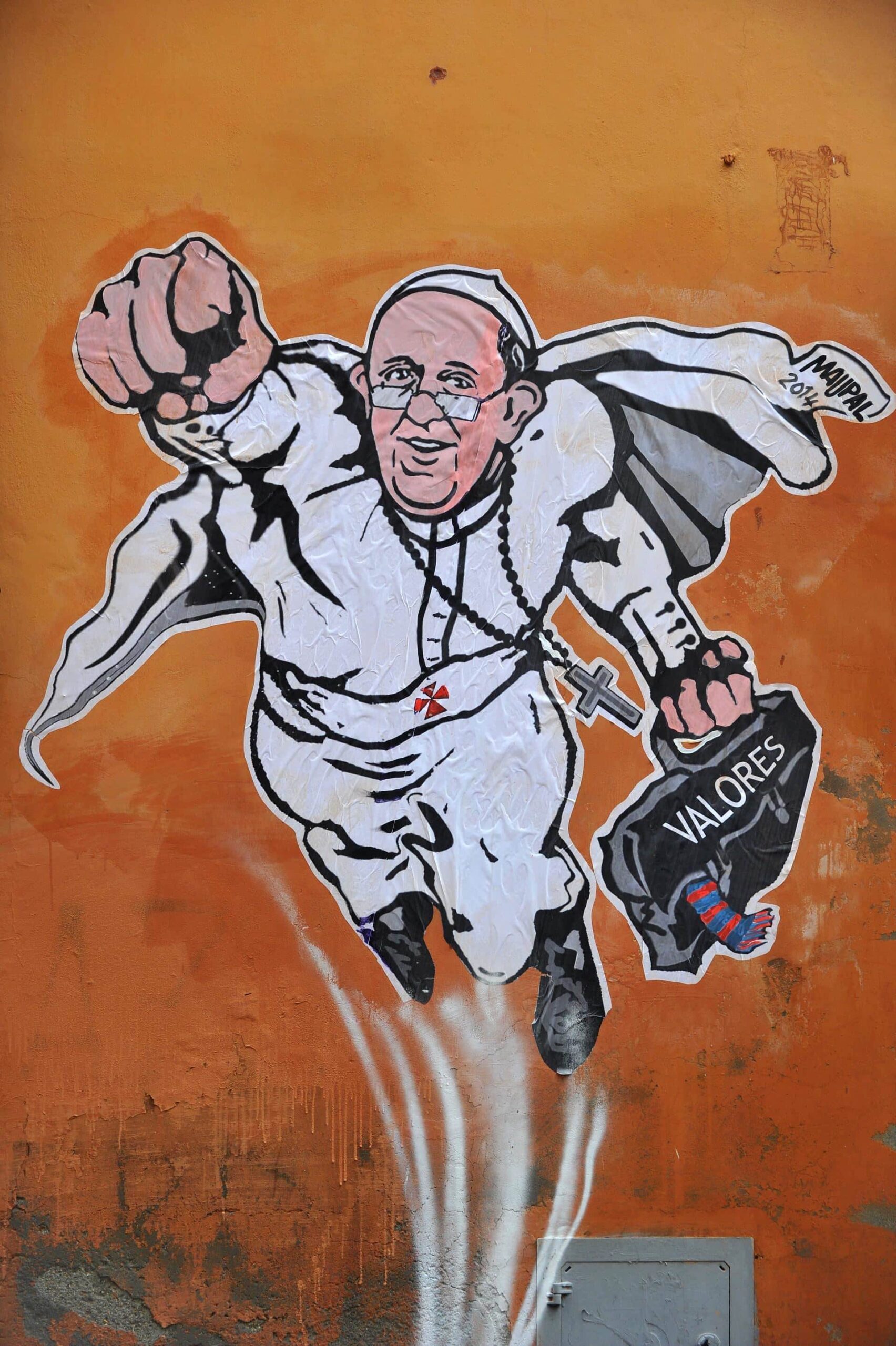 A picture shows a street art mural showing Pope Francis as a superman, flying through the air with his white papal cloak billowing out behind him and holding a bag bearing the word "Values", by Italian street artist Maupal in downtown Rome near the Vatican on January 29, 2014. The image, created by Italian street artist Maupal, was tweeted yesterday by the Vatican communication twitter account ( @PCCS_VA ). Flying forward with his fist raised, the heroic pontiff -- crucifix swinging in the wind -- carries his trademark black bag, with the word "values" written across it in white. AFP PHOTO / TIZIANA FABI (Photo credit should read TIZIANA FABI/AFP/Getty Images)