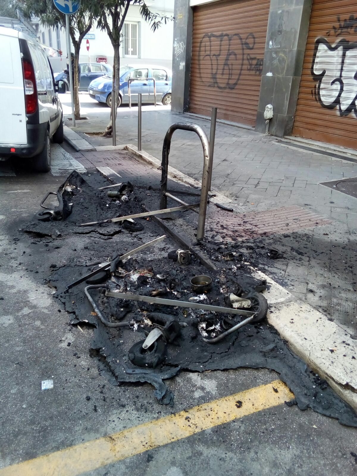 I resti dei due cassonetti bruciati nel quartiere Libertà