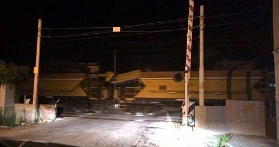 Il passaggio a livello aperto a Santo Spirito mentre il treno attraversa i binari