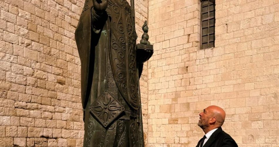 24-02-26 quarto anniversario dell'invasione russa in Ucraina bandiera ucraina sulla facciata di palazzo della Città, sindaco depone dei fiori sotto la statua di san Nicola_foto 1