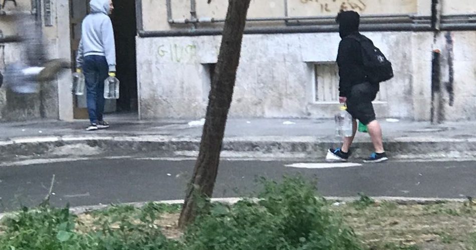 I residenti con le bottiglie di acqua