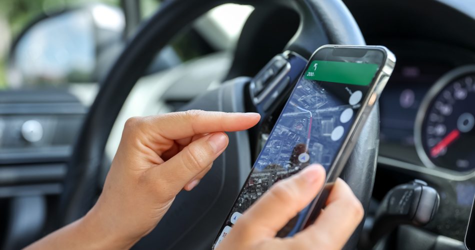 A woman driving a car use your smartphone to view a map showing your travel route and use the application to get to the destination.